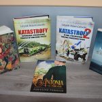 Cztery książki stojące na regale i jedna leżąca. „Pokora” Szczepan Twardoch. 2 tomy Serii „Katastrofy” Leszek Adamczewski. „Saturnin” Jakub Małecki. „Antonia na Podlasiu” Agnieszka Panasiuk.