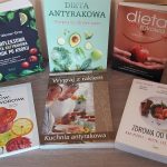 Sześć książek na temat diety antyrakowej ułożonych na komodzie.