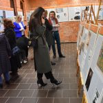 Ludzie oglądają wystawę na planszach i sztalugach.