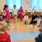 Wszyscy wspólnie pracują podczas zajęć w bibliotece na kole współpracy.