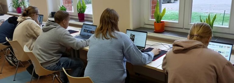 Uczestnicy uczą korzystać się z laptopów.