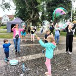 Na zdjęciu widzimy dzieci puszczające bańki mydlane.