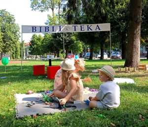 Dzieci siedzące na piankach w parku.