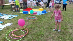 Dziecko rzuca hula hop do wyznaczonego celu, którym jest balon