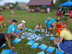 Bibliotekarze, dzieci i klaun odgadują grę w memory