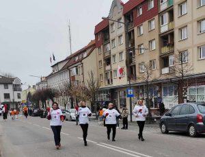 Na zdjęciu widzimy osoby biegnące w sztafecie.