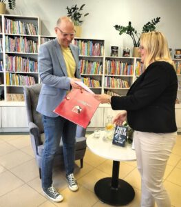 Na zdjęciu widzimy Panią wręczającą upominek autorowi.