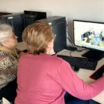 Dwie panie oglądają zdjęcie na stronie internetowej.