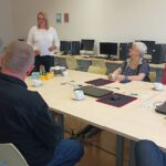 Pani dyrektor stoi i mówi do uczestników warsztatów.