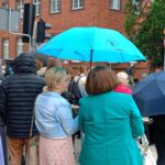 Grupa ludzi przechodzących przez pasy, nad uczestniczkami widać parasol z logiem naszej biblioteki.