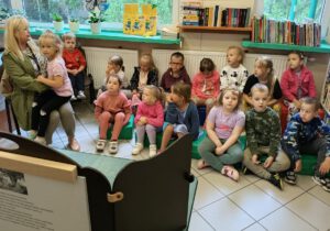 Dzieci z opiekunem słuchają czytanej bajki kamisihibai.