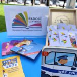Stół na którym są ustawione książki, zakładki w skrzynce.