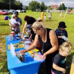 Uczestnicy festiwalu oglądają ksiązki ustawione na stole.