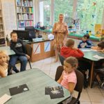 Pani opowiada dzieciom o zagrożeniach kąpieli w fontannach miejskich.