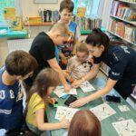 Dzieci robią swoje odciski palców z policjantką.