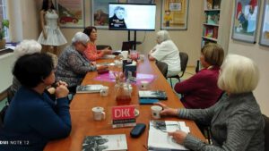 Uczestniczki spotkania siedzące za stołem.