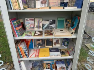Półki z książkami w otwartej szafie bookcrossingowej.
