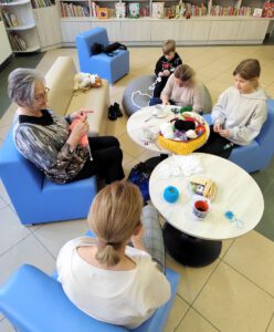 Grupa uczestników wykonuje swoje prace rękodzielnicze.