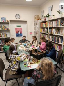 Dzieci tworzą pracę plastyczną z szyszek i kasztanów, plasteliny, włóczki.