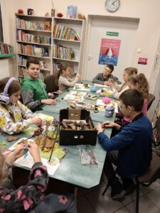 Dzieci tworzą pracę plastyczną z szyszek i kasztanów, plasteliny, włóczki.