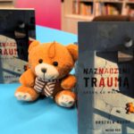 Miś pośrodku ułożonych książek.