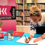 Autorka wpisująca się do księgi pamiątkowej.