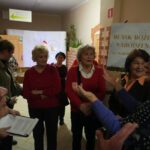 Na zdjęciu widzimy uczestników wernisażu wystawy częstujących się kolorowymi bombkami.