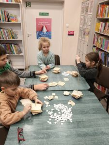 Dzieci tworzą choinki z makulatury.