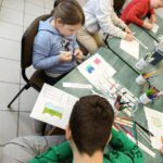 dzieci kolorują na białej kartce