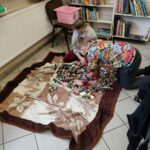 chłopiec z dziewczynką układają klocki na brązowym kocu.