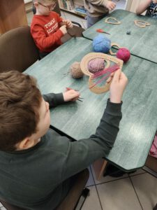 Dzieci wykonują prace plastyczne, wyszywają nicią.