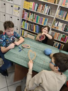 Dzieci wykonują prace plastyczne, wyszywają nicią.