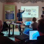 Na zdjęciu widzimy uczestników spotkania słuchających Pani omawiającą stronę internetową Policji.