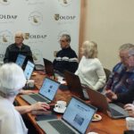 Na zdjęciu widzimy uczestników spotkania słuchających o bibliotecznej karcie zapisu.