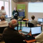 Na zdjęciu widzimy uczestników spotkania słuchających Pana omawiającego gołdapską kartę mieszkańca.