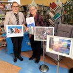 Zdjęcie dwóch kobiet jedna trzyma obraz z końmi, druga podziękowanie za udział w akcji.