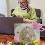 Na zdjęciu widzimy uczestnika spotkania pracującego na urządzeniu elektronicznym.