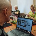 Na zdjęciu widzimy uczestnika spotkania pracującego na urządzeniach elektronicznych.