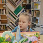 Zdjęcie przedstawia książkę trójwymiarową, którą trzyma dziewczynka.