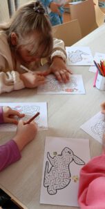 Na fotografii widoczne dzieci kolorujące.