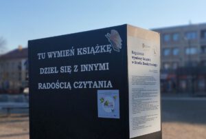 Na zdjęciu widzimy szafę z napisem Tu wymień książki dziel się z innymi radością czytania.