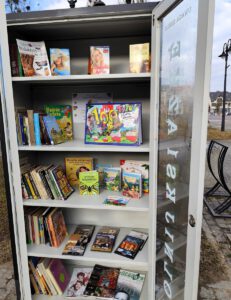 Otwarta szafa wypełniona książkami.