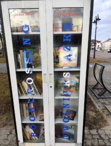 Szafa bookcrossingowa zamknięta, drzwi szafy są w rosie.