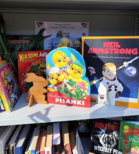 Na zdjęciu widzimy ustawione książki, w pierwszym kadrze widnieje królik drewniany oraz książka o Wielkanocy.