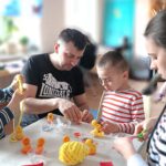 Fotografia przedstawia rodziców z dwójką dzieci tworzących kurczaczki wielkanocne.