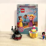 Książki ustawione na półce,przed książkami stoją ustawione figurki z lego